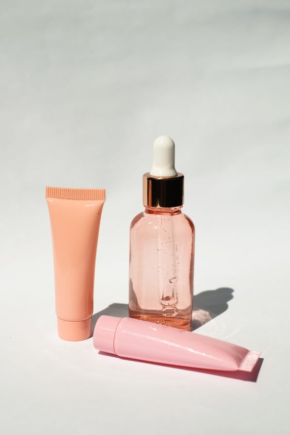 Serum Bottle and Cosmetic Tubes on White Background